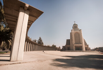 a concrete building with some tall pillars next to it on a sunny day