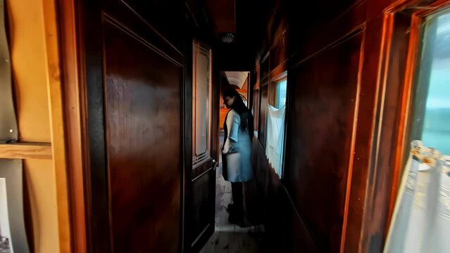 A Woman Is Looking Inside The Old Fashioned Train Compartment. Tracking Shot