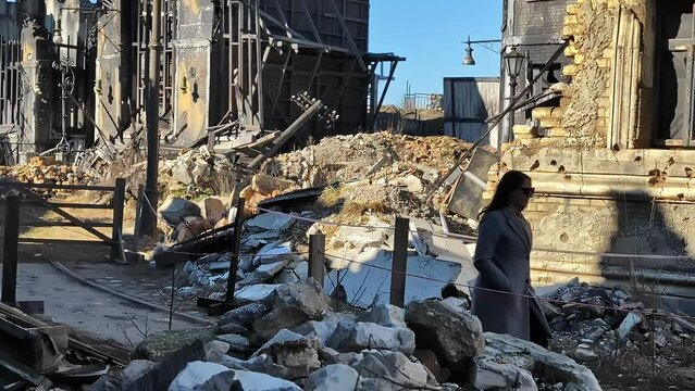 Woman walking through a war-torn city - movie studio for an urban war scene