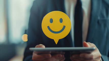 Businessperson holding tablet a digital smile icon on speech bubble, emphasizing customer satisfaction and positive feedback, Concept of business success and client relations.