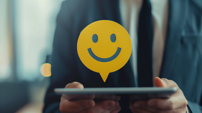 Businessperson holding tablet a digital smile icon on speech bubble, emphasizing customer satisfaction and positive feedback, Concept of business success and client relations.