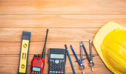 Top view desk of Engineer tools meticulously designs structures at desk, referring to blueprints...
