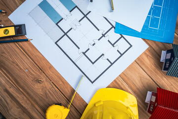 Top view desk of Engineer tools meticulously designs structures at desk, referring to blueprints...