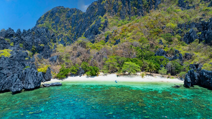  white sand beach bathed by a crystal clear water. Entalula island, Bacuit Bay, El Nido, Palawan, Philippines.