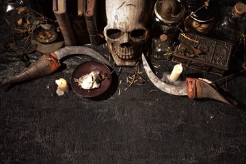 High angle view of a skull with lit candles and books on a black table - cool for backgrounds