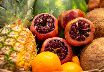Close-up of sliced pomegrante fruit surrounded by pineapple, watermelon, oranges and coconut at a fruit stand in Istanbul, Turkey - Powered by Adobe