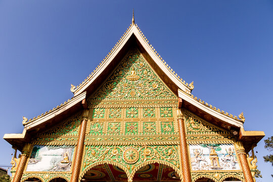 gold and green ornate buddhist temple in vientiane, loas