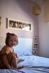 Happy little girl in the parents bedroom