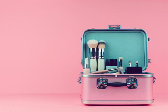pink case with make up brushes and cosmetics on the pink background