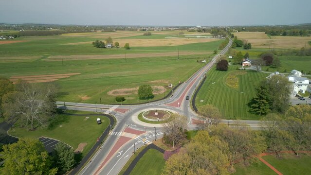 Traffic circle with vehicles traveling on it. Aerial drone view.