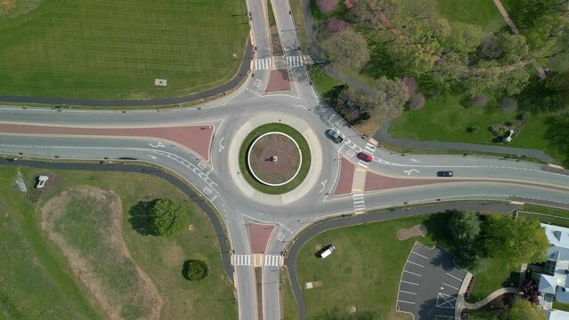 Traffic circle with vehicles traveling on it. Aerial drone view from directly above.
