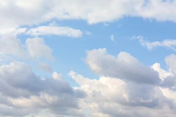 Bright day sky with fluffy cumulus clouds scattered across a vibrant blue backdrop, perfect for...