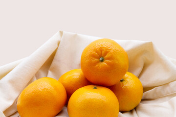 Mandarin oranges placed in tote bag isolated on beige background. Oranges texture with the concept...