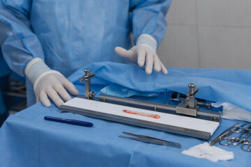 surgeons work on the cut part of the knee joint (muscular ligament) before implanting it back into the patient's knee