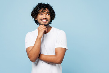 Young happy Indian man he wear white t-shirt casual clothes put hand prop up on chin, lost in...