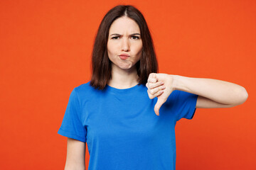 Young sad dissatisfied displeased woman wear blue t-shirt casual clothes showing thumb down dislike...