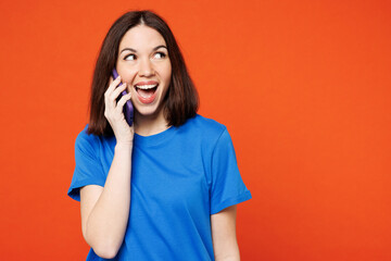 Young surprised shocked excited happy woman wear blue t-shirt casual clothes talk speak on mobile...