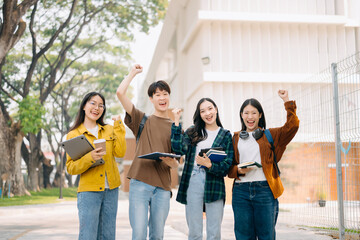 Obraz premium Asian Students are studying the campus park. Young people are spending time together. Reading book, working with laptop, tablet