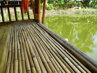 Image of a water pond with lotus plants above it. The pool has a beautiful view with shadows of...