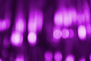 Blurred violet purple abstract background with light bokeh. Festive, Christmas, New Year, Valentine's or anniversary party. Decoration and holiday illumination concept