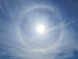 The storng sun halo at noon time on the blue sky