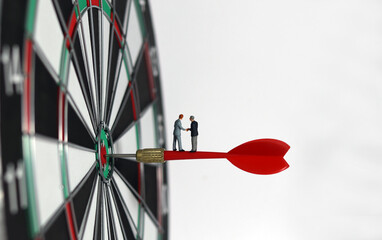 Business marketing success concept. A miniature businessman standing on a red arrow in the middle...