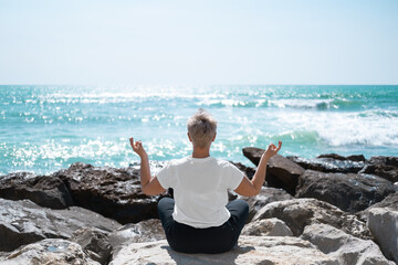 Middle Aged Female Doing Yoga Exercises. Mindfulness Zen Spiritual Meditation Tips. Kundalini Yoga. Reiki Meditation. Relaxing. Unity With Nature. Sea or Ocean Coast Beach
