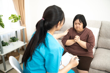 Female nurse holds the hand of her syndrome patient.