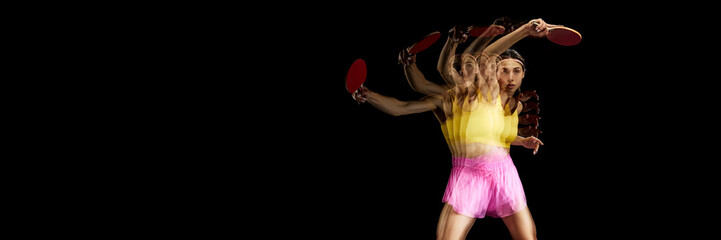 Focused young woman playing table tennis against black background with stroboscope effect. Concept...