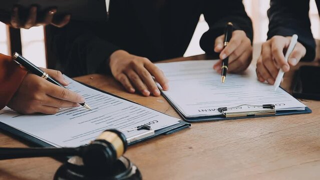 Justice lawyer meeting with contract papers and Judge gavel on tabel in courtroom. Attorney working in courtroom. Justice and law, attorney, court judge concept.