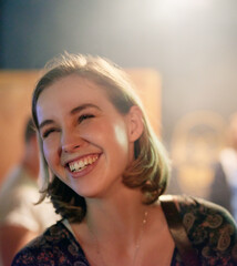 Woman, laugh and happy in restaurant for travel, concert and fun in city. Female person, smile and night out in urban town for party, dinner and celebration in club for enjoyment or socializing