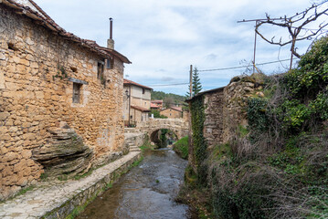 Panoramic view of the tourist village Tobera, small houses surrounding the river and in the background a small stone bridge.