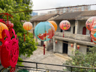 Colourful lanterns in the foreground and old Chinese village houses in the background
