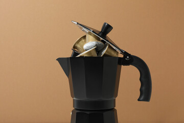 Golden coffee capsules in coffee maker on beige background, close up