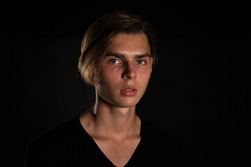 Obraz premium A young attractive guy is resting. Black background.
