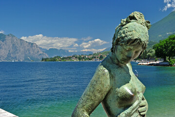Close Up of Modern Female Sculpture on Stone Jetty beside  Italian Lake with Distant Mountains on...