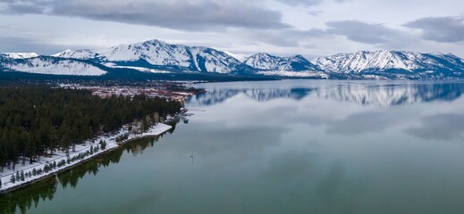 Calm mirror Lake Tahoe and mountains with snow. Tahoe Keys, South Lake Tahoe, California, United...