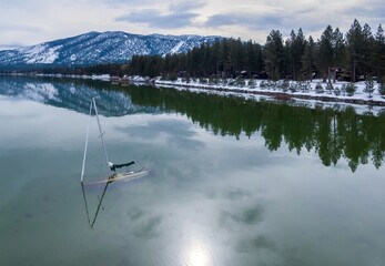 Sunken abandoned yatch and forest mountains with snow. Tahoe Keys, South Lake Tahoe, California,...