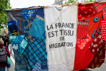 un drapeau aux couleurs de la France avec un slogan pro immigration pendant le défilé du 1er mai...