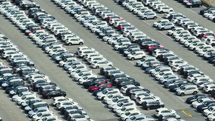 Like gems in a treasure chest, new cars rest gracefully on the ground, as seen from a drone's perspective, promising adventures yet to be taken. Powering progress through mobility. Vehicles concept.
