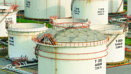 Industrial Majesty: An expansive oil depot sprawls beneath, a web of steel and tanks gleaming in...