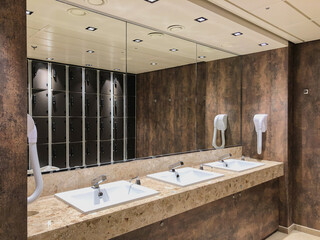 Metal hand air dryers with modern design tiles in bathroom on cruiseship or cruise ship liner