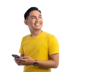 Happy young Asian man holding mobile phone and looking away with big smile isolated on white background