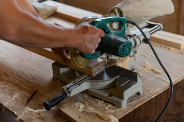 電動のこぎりで木材を切る