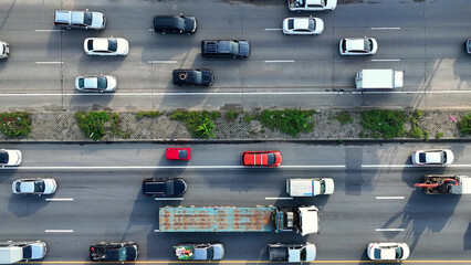 A bustling motorway during rush hour, captured from above by a drone, reveals a sea of vehicles...