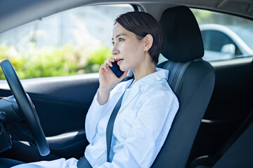 車内で電話をかける日本人医師