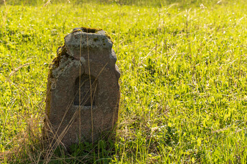 Worn-out and weathered, simple and uncomplicated, the headstone is made of natural stone....
