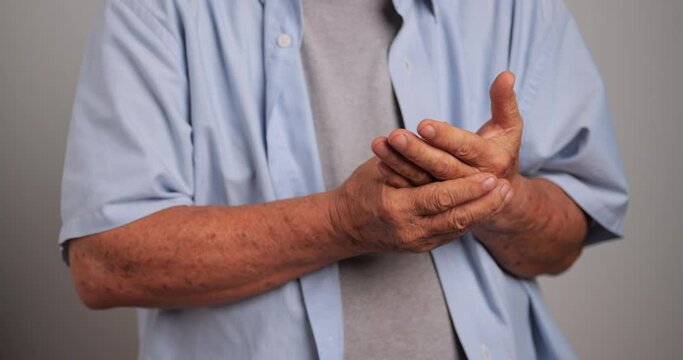 An elderly man's hand is trembling because of Parkinson's disease.