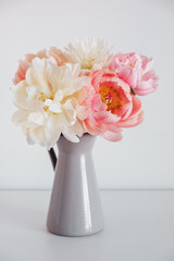 Beautiful fresh colorful peony flowers in full bloom in vase. Floral still life with blooming peonies.