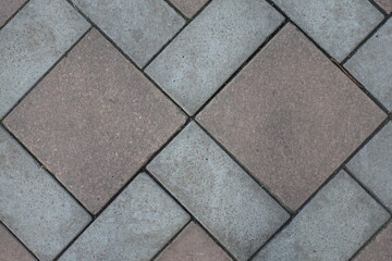 Close shot of geometric pavement made of grey and brown concrete tiles